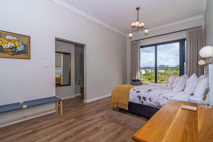 1号卧室 - 主卧。 标准双人床套房卫生间，附属于主屋，滑动门通往四分之一码头。