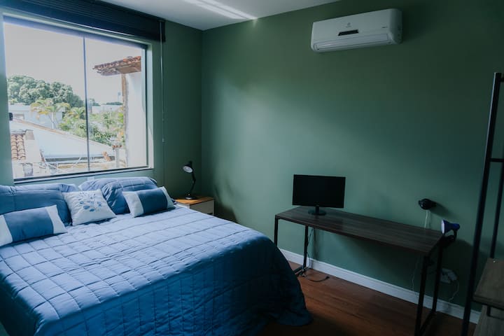 Configuração do quarto com uma cama queen.