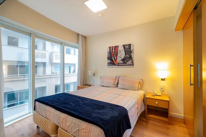 חדר שינה עם חדר רחצה פרטי, מצויד במיטת קווין סייז, מיזוג אוויר, טלוויזיה, מקום לאחסון בגדים, מראה באורך מלא, מצעים, שמיכות, כריות נוספות, וילונות האפלה ויציאה למרפסת.