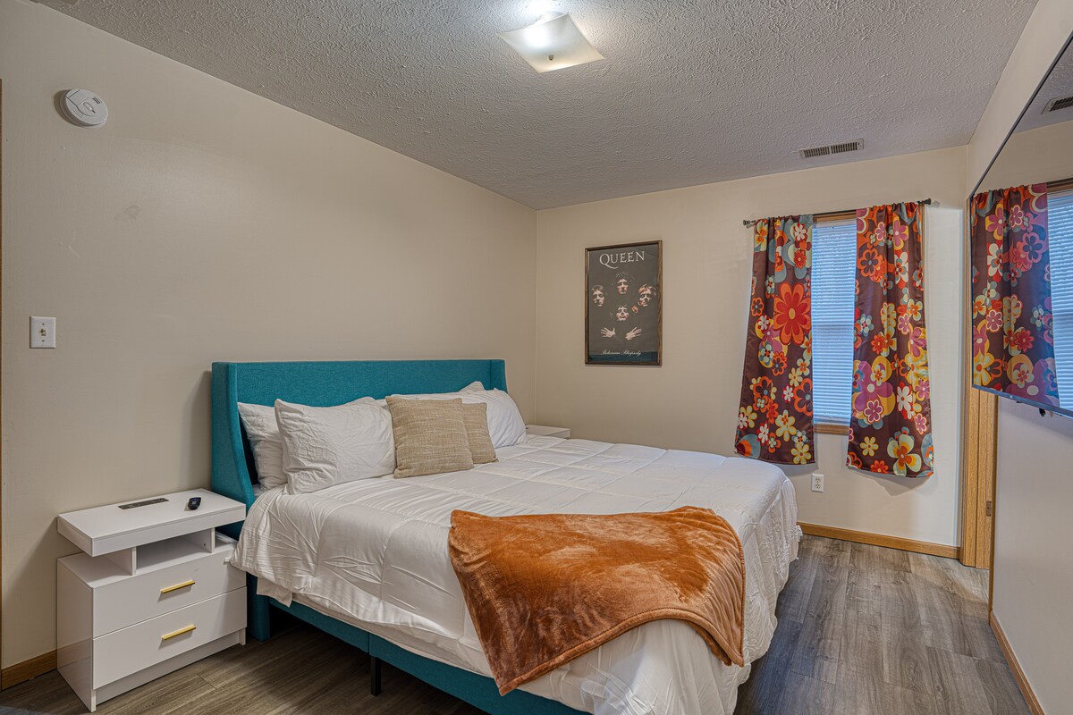 Habitación tranquila con una lujosa cama tamaño king, sábanas suaves y cortinas opacas para una noche de sueño reparador.