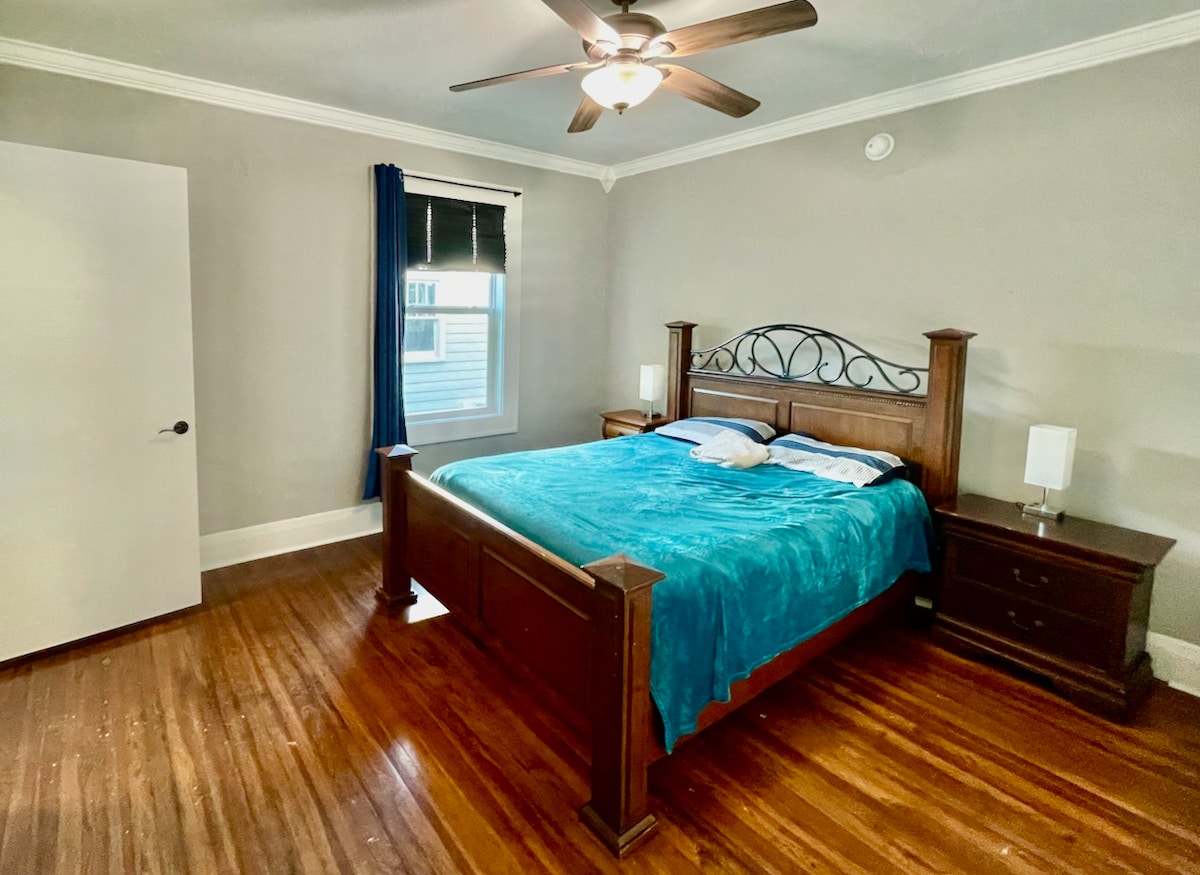 Velika spavaća soba na glavnoj etaži s privatnom kupaonicom. Uključuje bračni krevet i stropni ventilator.