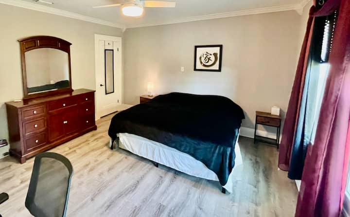 Grote kingsize slaapkamer 3 met plafondventilator, kast, kleedspiegels, dressoir en klein bureau met stoel.