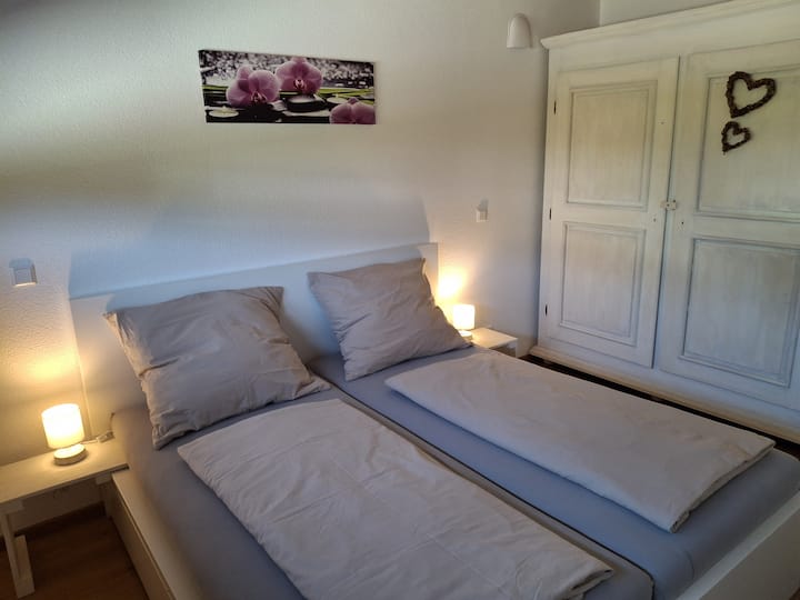 Chambre avec grand lit double confortable et armoire en bois massive. Possibilité de mettre des matelas sur le sol pour les jeunes enfants. 