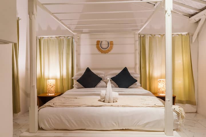 主卧配有加大双人床、柔和的灯光和热带魅力，是水明漾别墅三间放松卧室之一，靠近双六海滩。