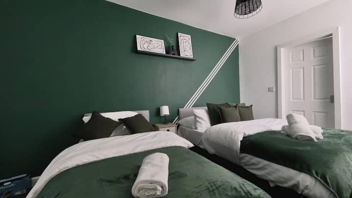 Modern Green Comfort: Ova spavaća soba s uređenjem zelene tematike i udobnim krevetom nudi moderan i opuštajući prostor. Živopisna shema boja i udoban namještaj čine ga idealnim za ugodan boravak članova grupe.
