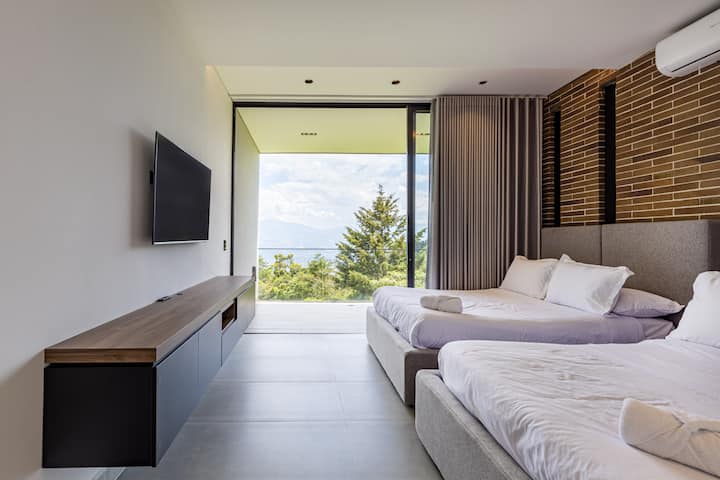 Despiértate con vistas a la montaña en este sereno dormitorio con dos camas dobles, TV inteligente y un diseño moderno y natural que combina estilo con comodidad.

