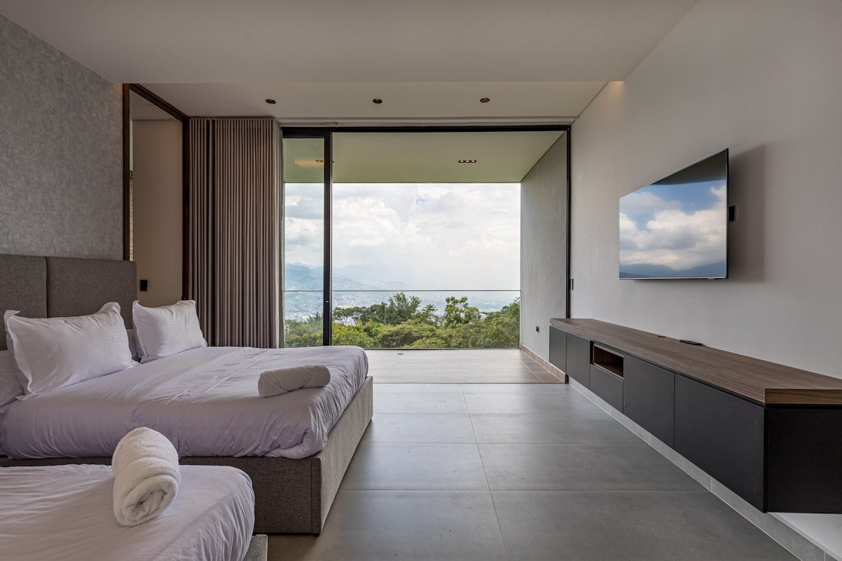 Despiértate con vistas panorámicas a la montaña en este dormitorio iluminado por el sol con dos camas dobles, acceso directo al exterior y un diseño moderno y minimalista.

