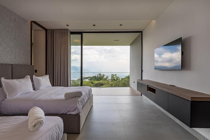 Despiértate con vistas panorámicas a la montaña en este dormitorio iluminado por el sol con dos camas dobles, acceso directo al exterior y un diseño moderno y minimalista.

