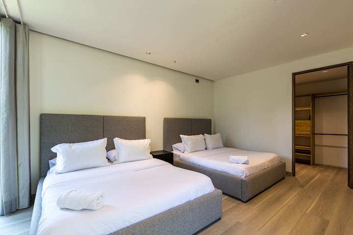 Disfruta de un descanso tranquilo en esta habitación luminosa y acogedora con dos camas tamaño queen, sábanas suaves, aire acondicionado y un acabado moderno y limpio.

