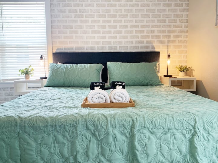 غرفة نوم في الطابق العلوي مع سرير بمقاس كينج وخزانة وتلفزيون ذكي وإمكانية الوصول إلى الشرفة الخلفية.