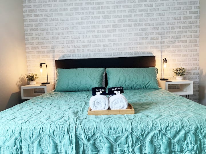 غرفة نوم في الطابق العلوي مع سرير بمقاس كبير وخزانة وتلفزيون ذكي.