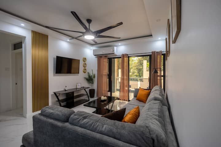 Détendez-vous dans ce salon avec un canapé sectionnel gris, une table basse en verre et une décoration contemporaine, créant une ambiance idéale pour se détendre ou se divertir.