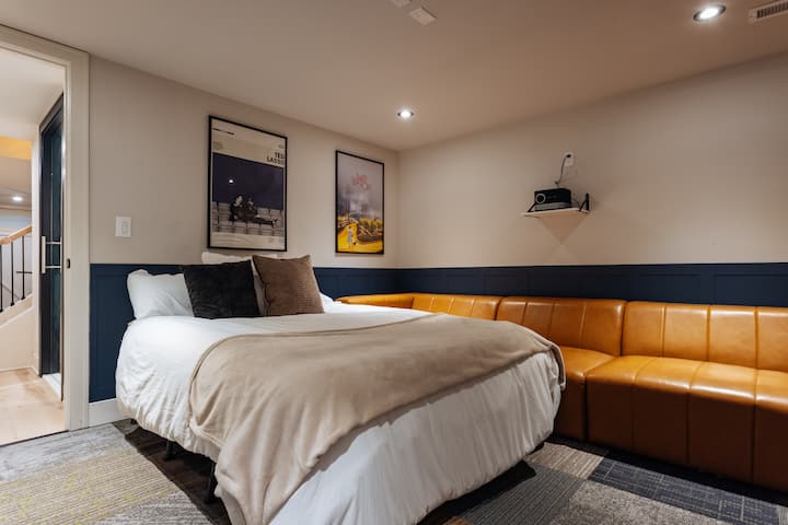 This cozy basement room does double duty. Your private movie theater by day & 5th bedroom by night. The queen air mattress with elevated base offers a surprisingly comfortable spot to wind down. The 11-foot sofa sleeper may also be used as a bed!