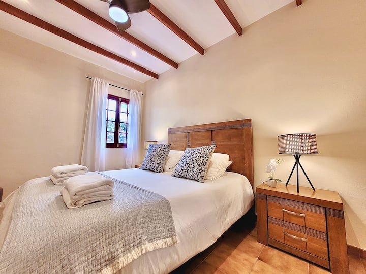 Dormitorio con cama doble, ventilador de techo y aseo / Bedroom with double bed, ceiling fan and toilet 