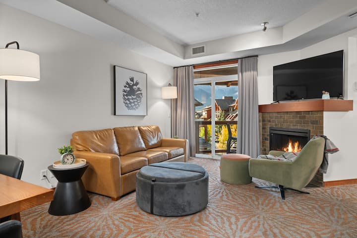 Rilassati nella tua accogliente zona giorno, completa di un comodo divano, un caminetto caldo e una vista sul balcone.