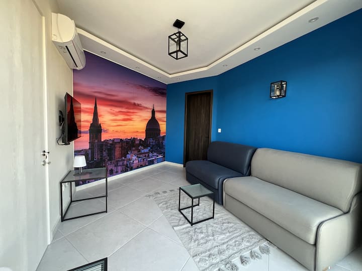 A private living room with two sofa beds, Alexa voice assistant, a voice-controlled air condition, and a TV that wirelessly projects a Windows laptop screen for presentations or productivity. Experience a versatile space for relaxation or work.