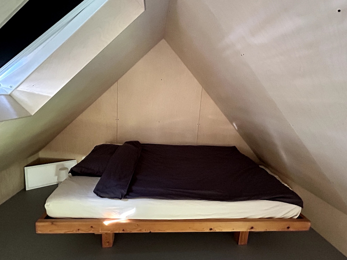 На мезанинот има кревет за двајца (140 x 200 см), високо во главната соба. Тоа е удобно, сонливо место во целосно дрвениот ентериер. LED-панелот во левиот агол е одличен за читање кога лежите во кревет. 