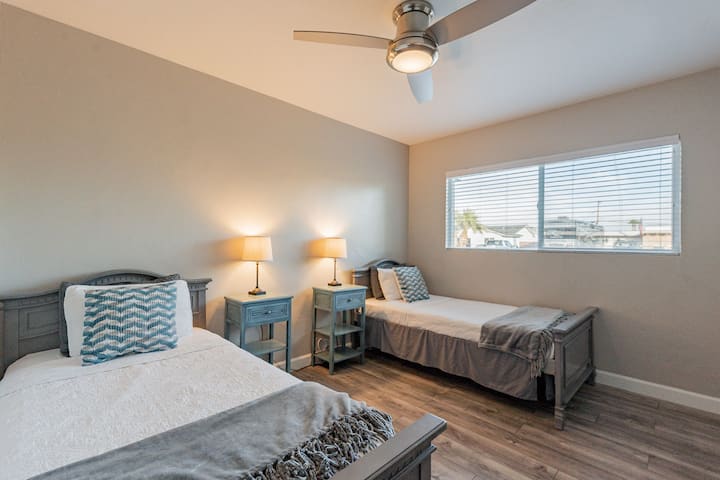 Tercer dormitorio con dos camas individuales y lámparas y mesitas de noche separadas. 