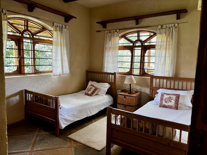 This room comfortably accommodates two people with twin beds that can be converted into a king-size bed for couples. Located on the ground floor, it opens directly into the living room and kitchen area. 