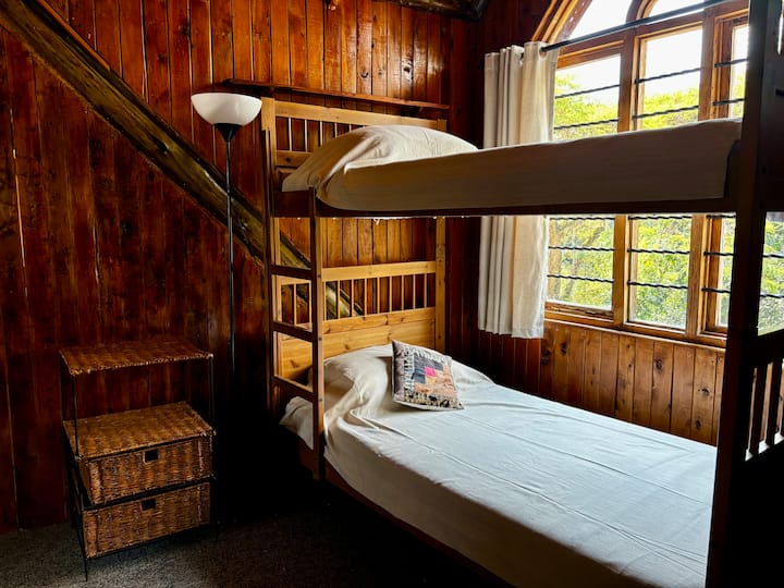 A set of bunk beds is tucked into the north-facing dormer window, nestled cozily behind curtained walls. It's an ideal space for young guests. A full bathroom with a bathtub serves this upstairs area.  