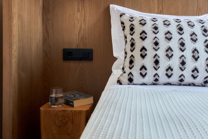 上階のユニット、2つ目の寝室。 魅力的なサイドビューを楽しめる大きな窓がある居心地の良い寝室。 柔らかく暖かい色調と贅沢なテキスタイルが、リラックスするのに最適な魅力的な雰囲気を作り出しています。