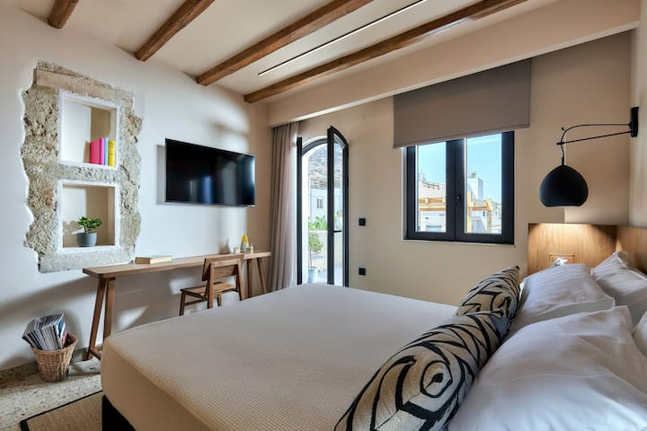 上層階のユニット、1つ目の寝室。 広々としたバルコニー付きのスタイリッシュな寝室で、ヘルソニソス港の息をのむような景色を眺めることができます。 大きなバルコニーのドアと窓から部屋に自然光があふれ、明るく風通しの良い雰囲気を作り出しています。