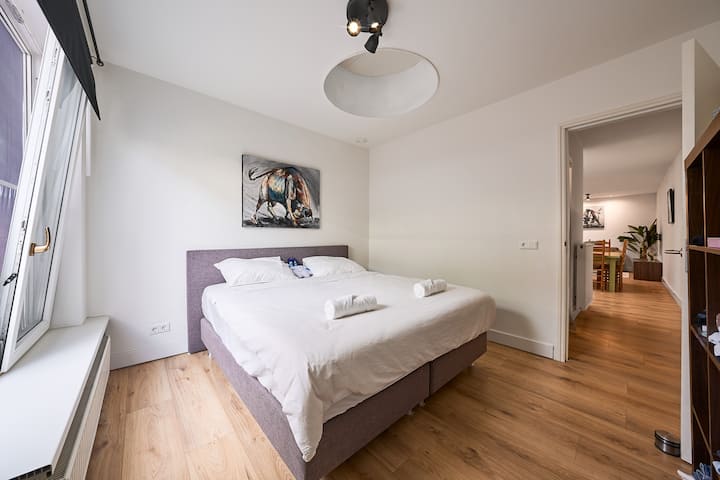 Опуштете се во удобноста на брачен кревет (широк 150-179 см), надополнет со голем прозорец кој пропушта природна светлина, прекрасна слика и стилски полици кои придонесуваат за шармот и функционалноста на собата.