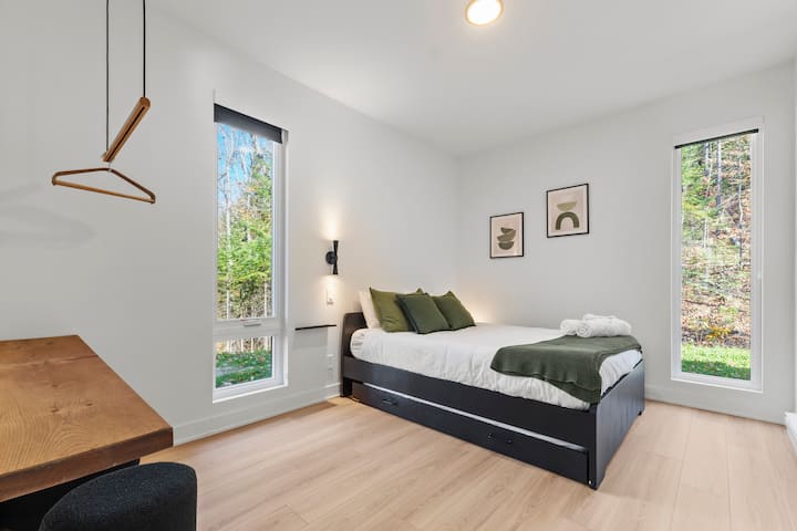 Spacious bedroom equipped with a queen bed and a double drawer bed with memory mattress as well as a desk. 