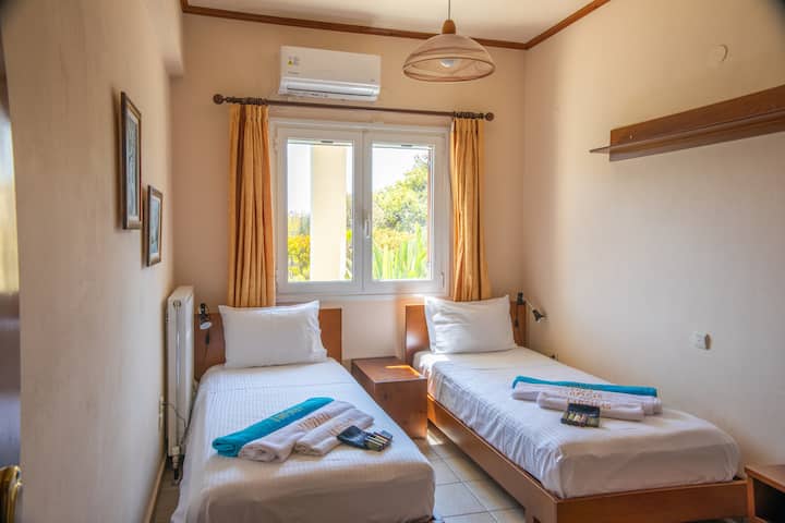 חדר שינה 2 בקומה הראשונה עם 2 מיטות יחיד המשקיפות על הגינה