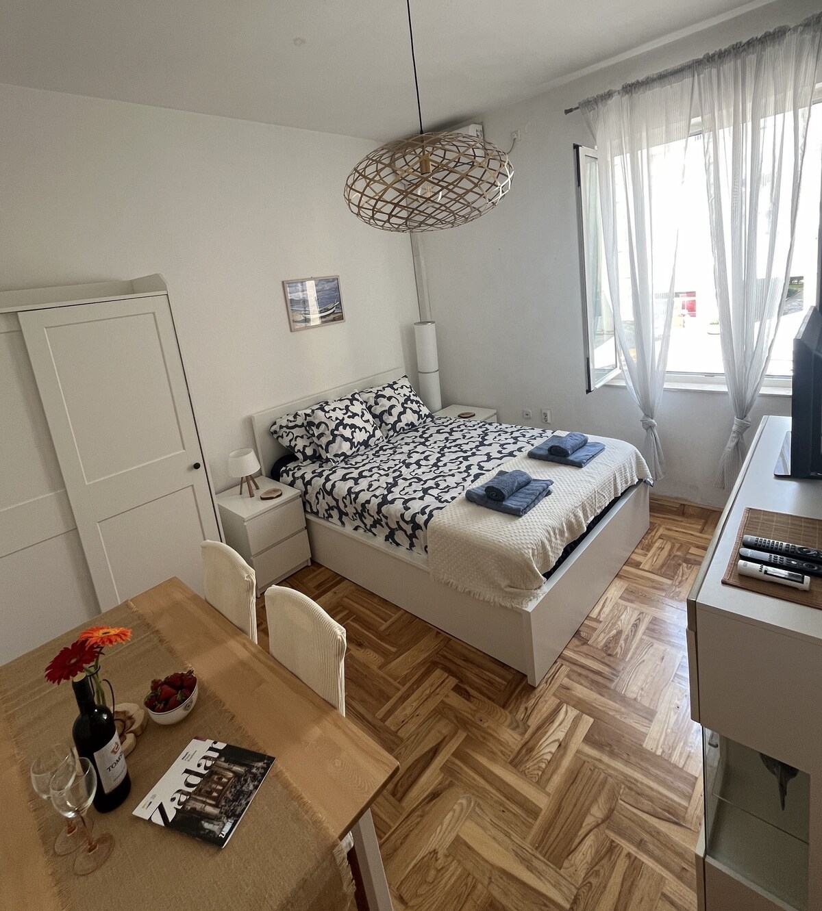 Disfruta de la comodidad en la sala de estar del apartamento estudio Zadar Liberta, con vino, cama acogedora, TV y una decoración encantadora en el corazón del casco antiguo.