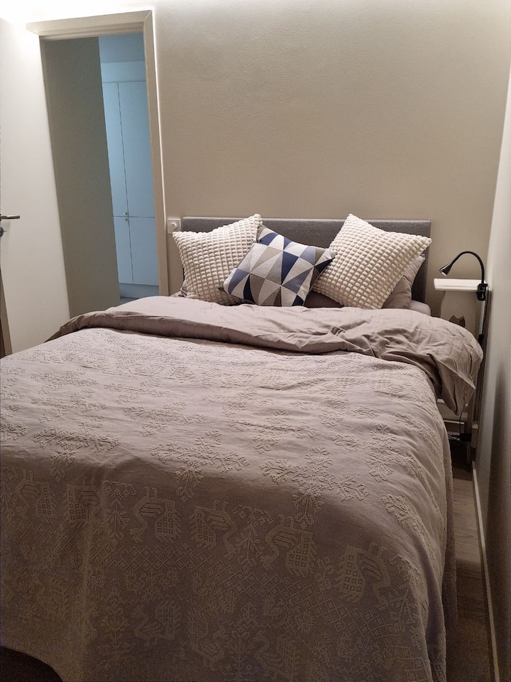 Cama doble (140 cm). El baño (con bañera) justo afuera de la puerta (al final del pasillo). En el pasillo hay un armario y lavadora con secadora. 