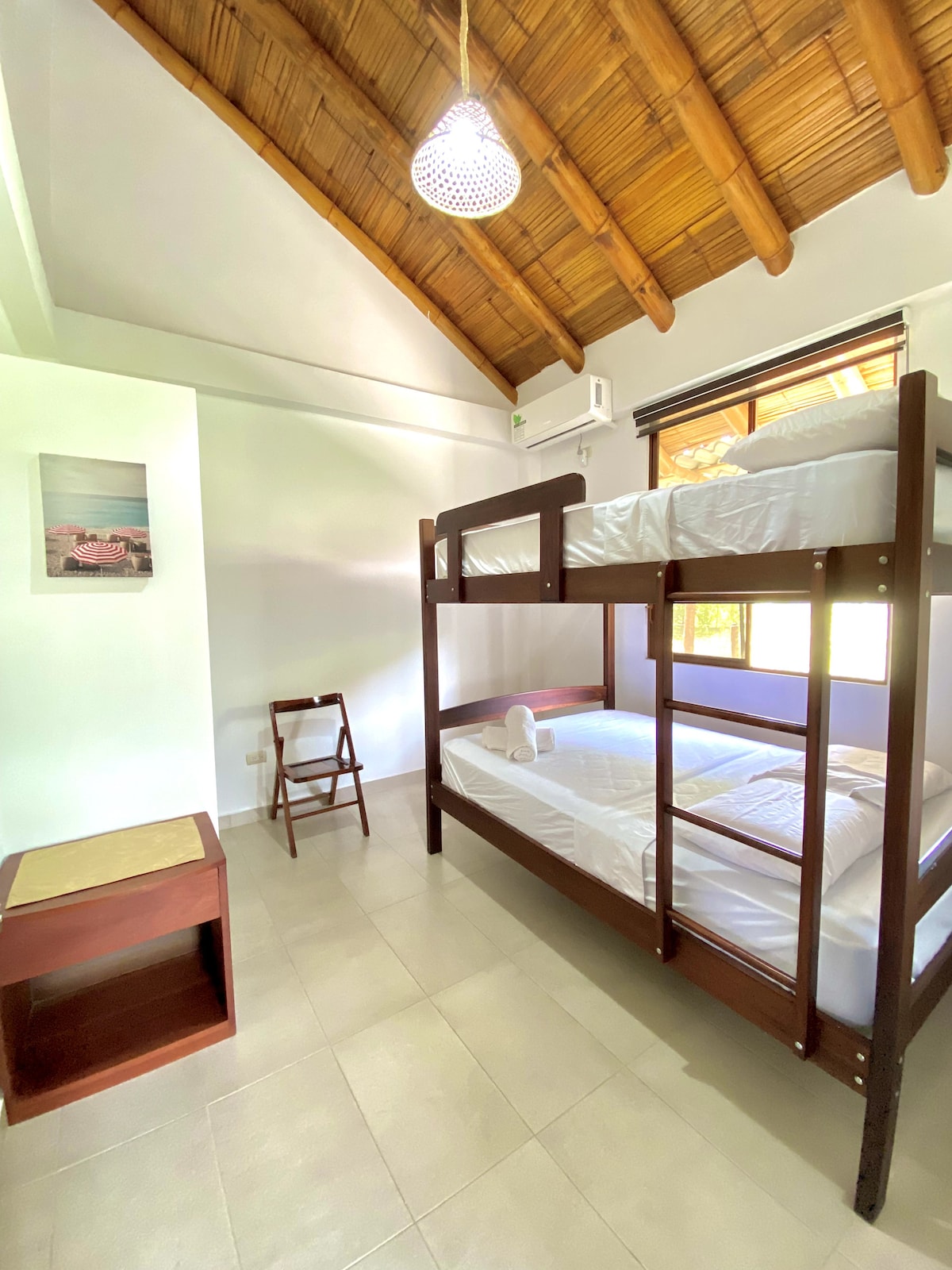 חדר שינה שלישי עם מיטת קומותיים וחלון רחב כדי שתוכלו ליהנות מאור השמש. הוא מציע שירותים בסיסיים לאורח, כמו מיזוג אוויר, מצעים ללא רבב, תריסים, מגירה ועוד. מקום נוח לנוח בו במהלך השהייה.