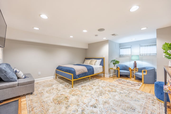 Amplio espacio abierto (divisor si es necesario) dormitorio de nivel inferior gran alfombra con juegos de mesa y libros, creando un ambiente divertido y tranquilo. Equipado con un televisor para el entretenimiento. Este espacio cuenta con una cama tamaño queen y un futón tamaño individual. 