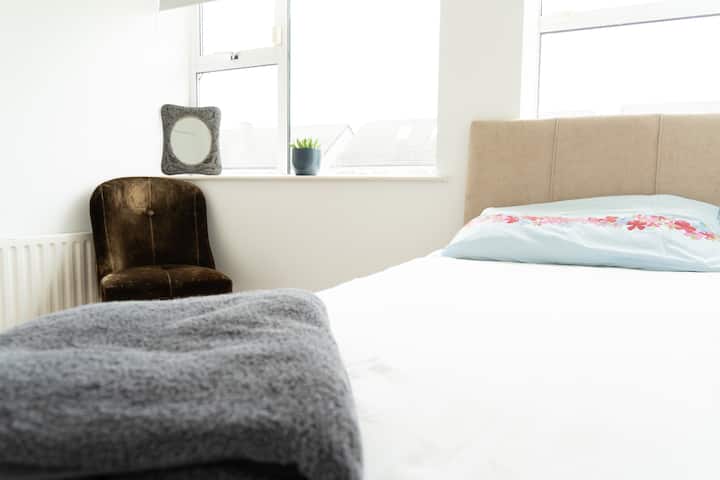 Hiki ni chumba kimoja cha kulala kilicho na kabati kubwa la nguo na kiti na luva nyeusi. 