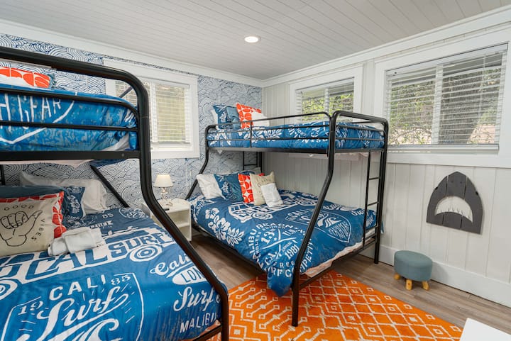 Habitación con literas para niños. Cama individual sobre literas dobles. Smart Roku TV montado en la pared a la derecha de esta imagen.