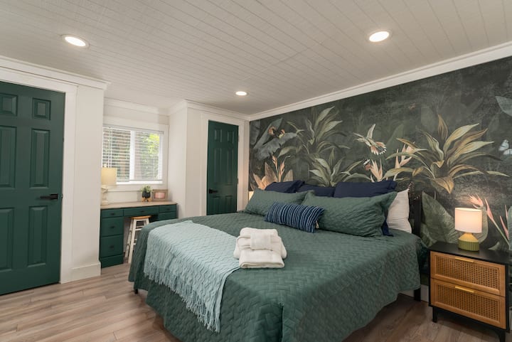 Dormitorio en el primer piso con una cama tamaño king y una estética única en la selva con un espacio de trabajo