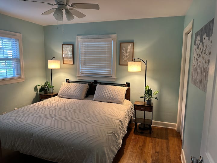 Este quarto tem uma cama king size, cômoda e armário com cabides.