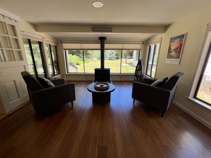 4 sillones reclinables frente a la vista parcial del leke y vistas al patio trasero de la montaña (estufa de gas en el centro). Nuestro “círculo de conversación”