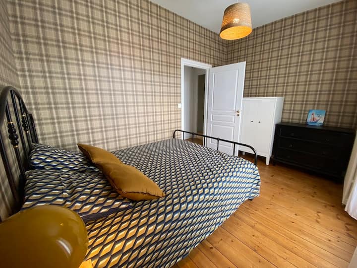 Chumba cha kulala chenye kitanda kikubwa na fanicha ya kuhifadhi.