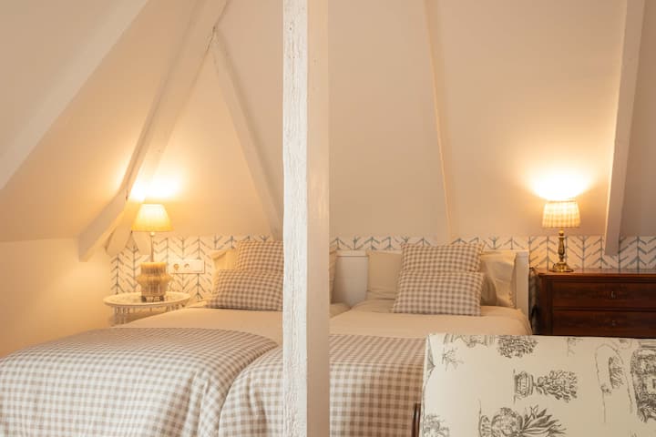 Amplia habitación en el ático con 2 camas individuales, vestidor y baño privado. También cuenta con un escritorio y canapé para relajarse y disfrutar. Bonitas vistas a la montaña del Cuera.  