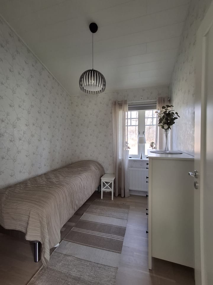 Chumba cha kulala chenye kitanda cha kawaida chenye ukubwa wa sentimita 200x90. Kitanda kina chemchemi ya sanduku pamoja na godoro la godoro. Chumbani pia kuna meza kando ya kitanda, taa ya kando ya kitanda na kabati la kuweka nguo.