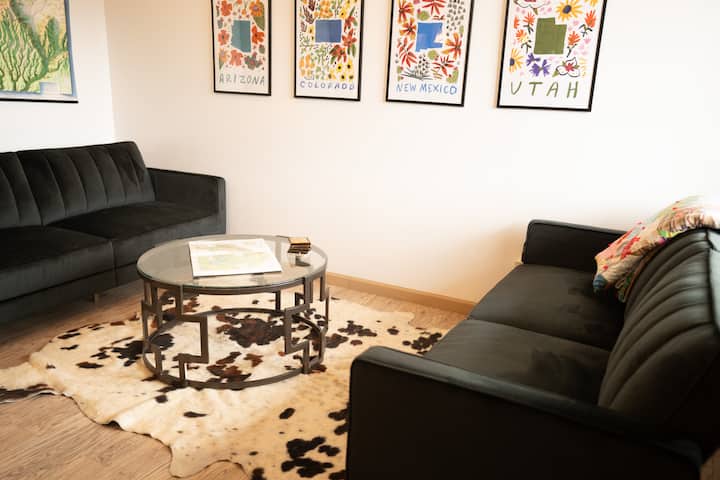 Ორი გასაშლელი ტახტი ყავის მაგიდით და ძროხის ხალიჩით. 