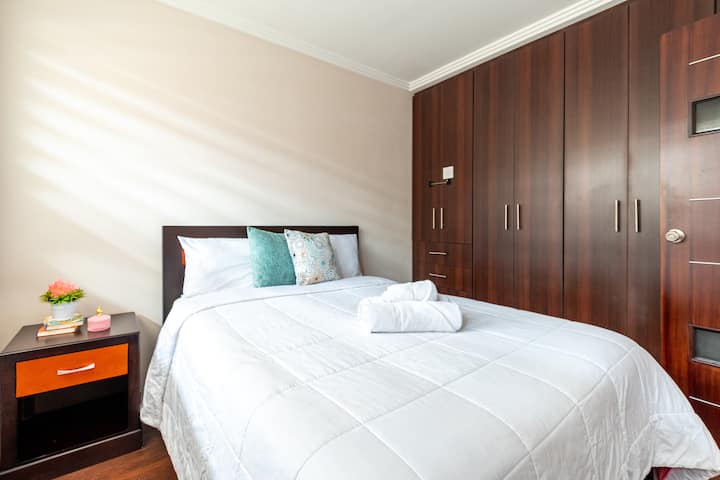 Soba s bračnim krevetom za dvoje ljudi, noćnim ormarićem, plahtama, pokrivačima, jastucima i jastučima za sjedenje, ormarom s vješalicama.