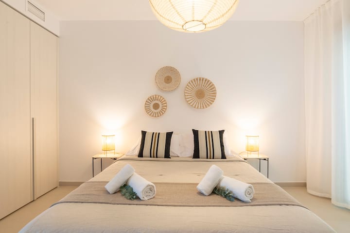 Cette chambre sereine dispose d'un lit confortable, de rideaux occultants pour un sommeil réparateur et de garde-robes intégrées pour garder votre espace bien rangé. Les tons naturels et l'éclairage chaleureux créent une atmosphère chaleureuse et accueillante.