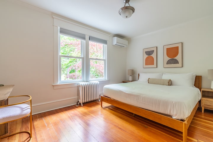 Спалня: слънчевата светлина влиза в стаята, подчертавайки шикозния декор и спокойния изглед към градината.