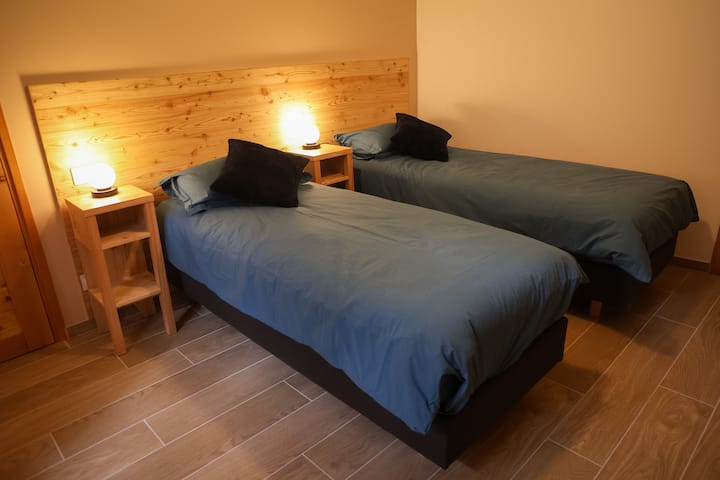 Chambre équipée de 2 lits simples modulables en 1 lit Queen Size avec salle de bain et WC privatif.
Literie haut de gamme Matelas RESSORTS - ROSA BONHEUR - NOYAU : Ressorts Full active 2.1 - CONFORT : Ferme - ACCUEIL : Mousse Supersoft