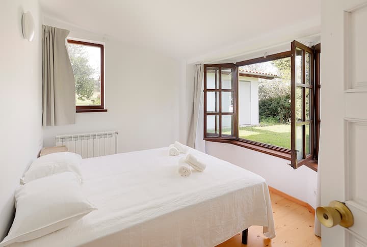 Ორადგილიანი ოთახი, რომელიც უკანა ბაღს გადაჰყურებს.