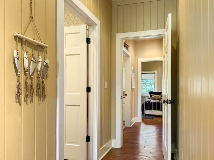 Korridori që shikon prapa me 2 banjat në të majtë, dhoma e ndenjjes në të djathtë.