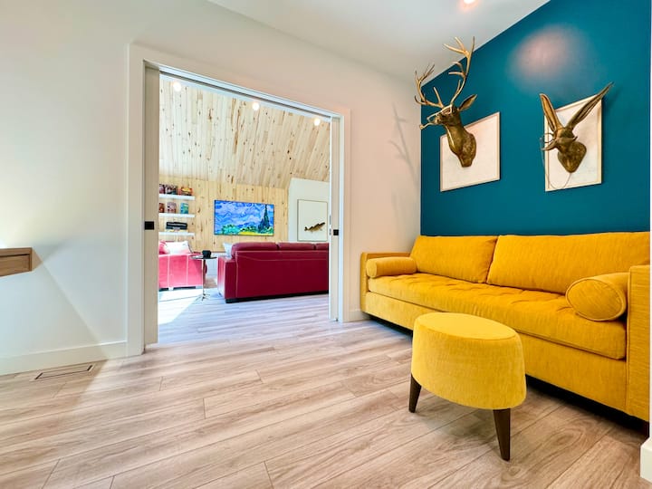 Bright and cozy office/bedroom featuring a stylish yellow couch that easily converts into a queen-sized pull-out bed. Sliding doors provide the option to close off the space for extra privacy, making it perfect for work or rest. 