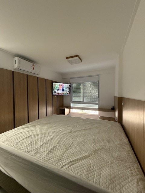 Suite con cama matrimonial tamaño queen, TV y aire acondicionado, además de espacio de trabajo